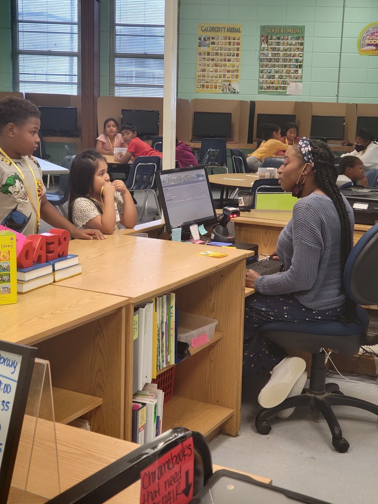 Mrs. Irving (Librarian) uses an electronic library system to help students check out books